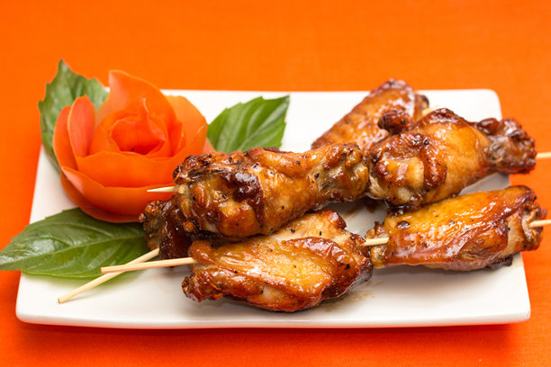 烤串上的烤鸡翅配番茄玫瑰装饰图片下载