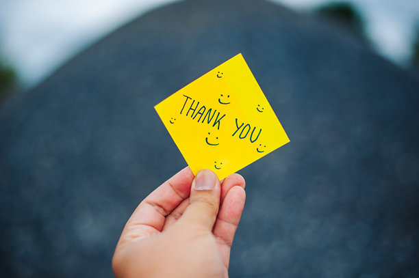 手持感谢卡片表达感激之情的姿势，户外场景，励志图片，特写镜头图片下载