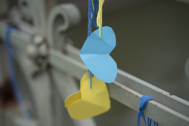 横向照片，展示了黄蓝色的纸心用蓝黄丝线系在桥栏上，象征乌克兰和民族团结。图片下载