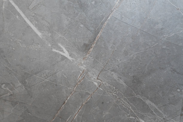 一张抽象的灰色大理石或天然石材纹理背景的详细照片，带有粗犷的白色和棕色对角线裂纹，适合奢华的建筑设计。图片下载