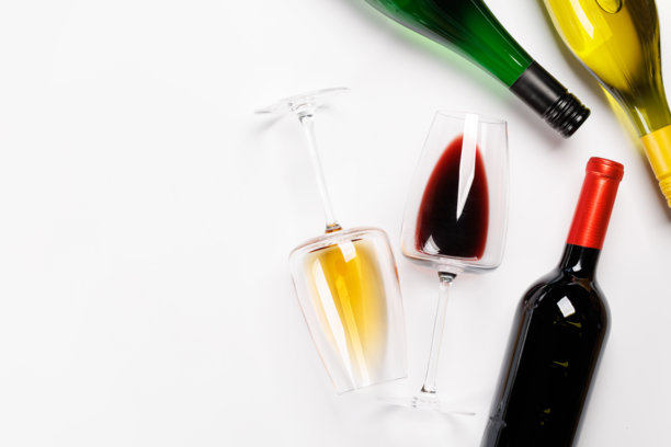 白色背景上摆放着红酒杯、白酒杯以及红酒和白酒的酒瓶图片下载