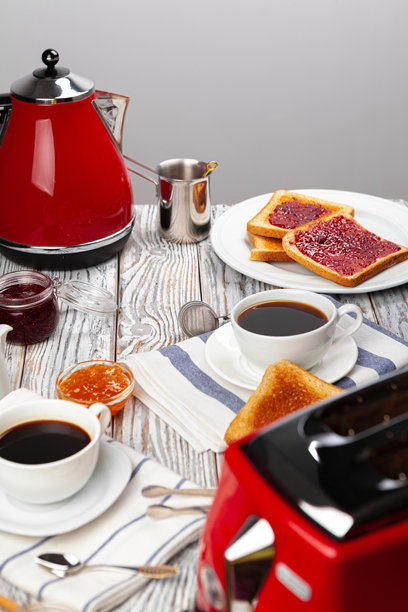 厨房桌子的特写照片，上面有电器、厨具、烤面包和果酱。图片下载