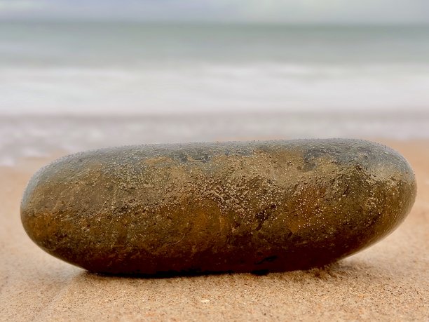 诺森伯兰郡布莱斯海边低潮时北海的长曝光照片，沙滩上有一块巨大的光滑岩石图片下载