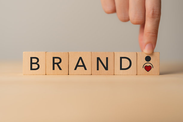 建立品牌与客户忠诚度的概念。木块拼写着“品牌”，以及心形和人物图标。品牌建设、信任和客户忠诚度。图片下载