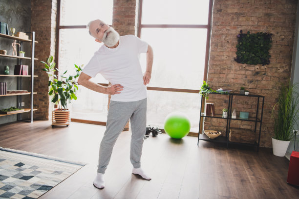 英俊的成熟运动男运动员在家中锻炼脊柱身体进行训练的全身照片图片下载