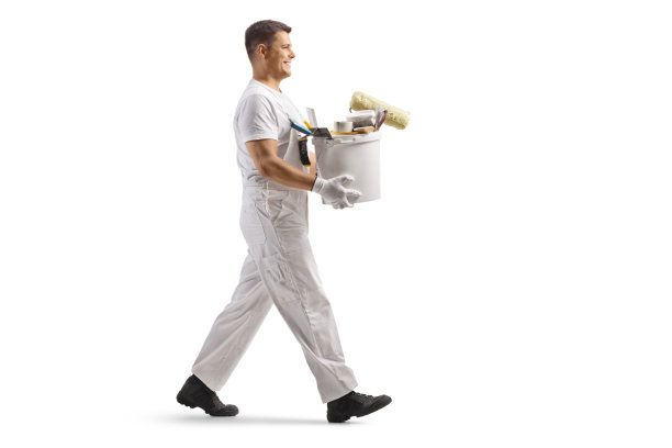 一名泥瓦工提着水桶行走的全身侧面照片图片下载