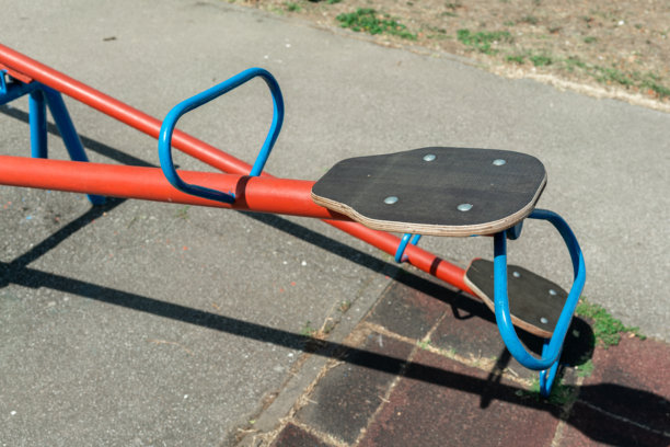 白天，一个空荡荡的复古跷跷板静止地立着。这张照片反映了童年、平衡、缺失、孤独、记忆、寂静和时光流逝的概念。图片下载