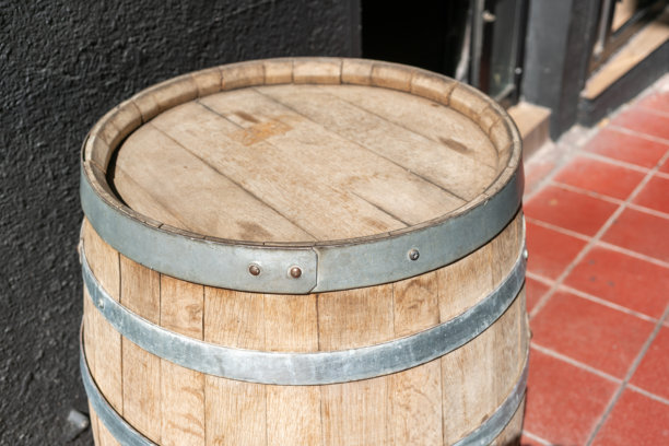 带金属箍和扁平盖子的木桶。这张照片在日常情境中传达了传统、储存、工艺、工业、传承和真实性的概念。图片下载