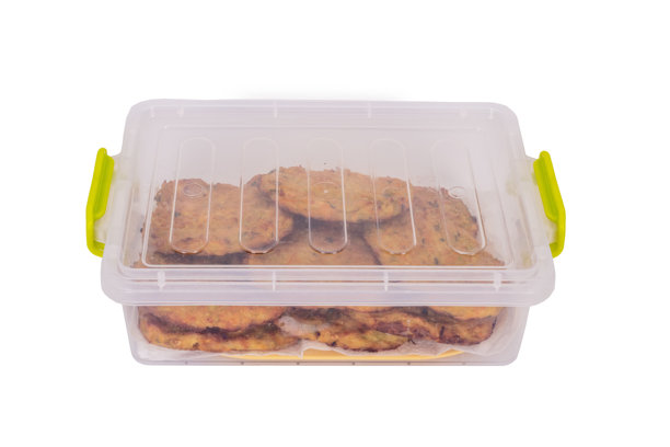 一张特写照片，展示了手工制作的蔬菜煎饼，整齐地摆放在透明的塑料容器中。金黄酥脆的煎饼外表可见香草和蔬菜碎屑。图片下载