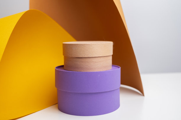 一套圆形的纸板包装盒，适用于化妆品包装、糖果装饰等，置于多彩背景上。这是用于品牌设计、产品设计或展示的现代样机。图片下载