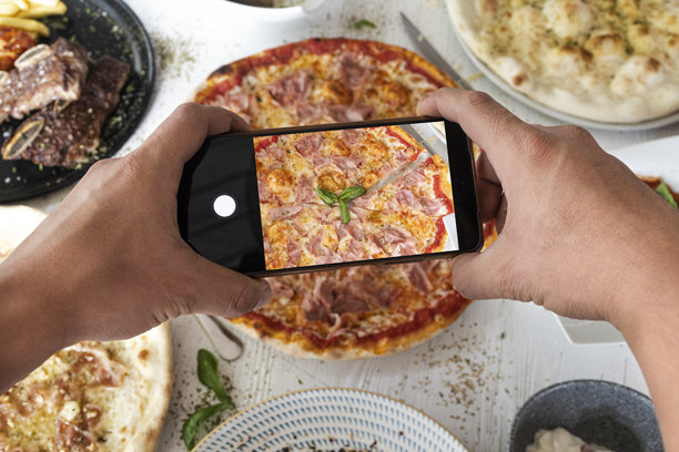 用智能手机为社交媒体拍摄美食照片的手图片下载