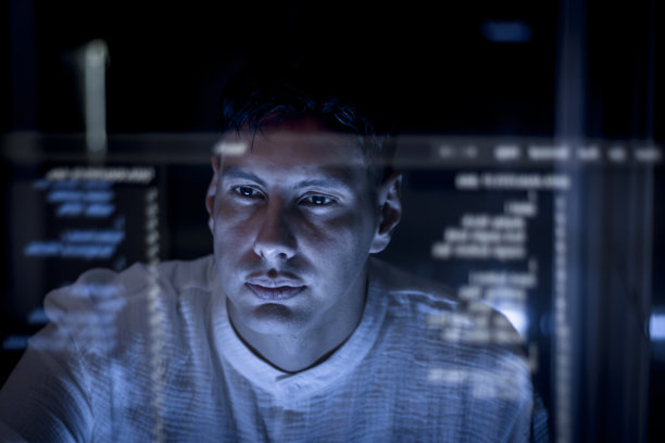 年轻的商人看着未来的屏幕阅读数字信息。一位有思想的数据分析师在办公室使用高科技工作。商业统计人员正在处理大量数字数据。图片下载