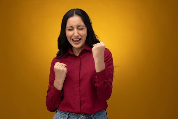 年轻的女商人穿着正装，在黄色背景下被隔离的素材照片图片下载