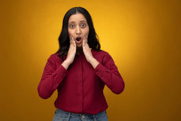 身着正装的年轻女商人在黄色背景下独立的照片素材图片下载