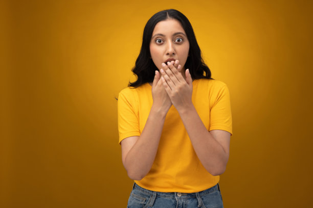 身穿黄色T恤的年轻女子，背景为黄色，孤立的照片素材图片下载