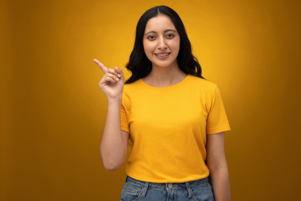 身穿黄色T恤的年轻女子，背景为黄色，摄影素材图片下载