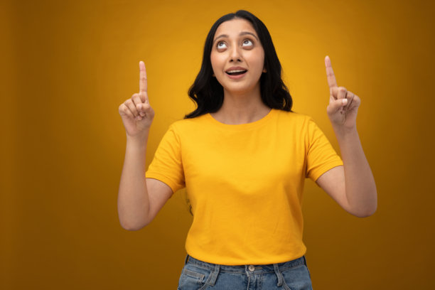 身穿黄色T恤的年轻女子，背景为黄色，孤立的素材照片图片下载