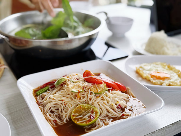 泰国辣味面条装在白色碗里，放在木桌上，素材图片图片下载