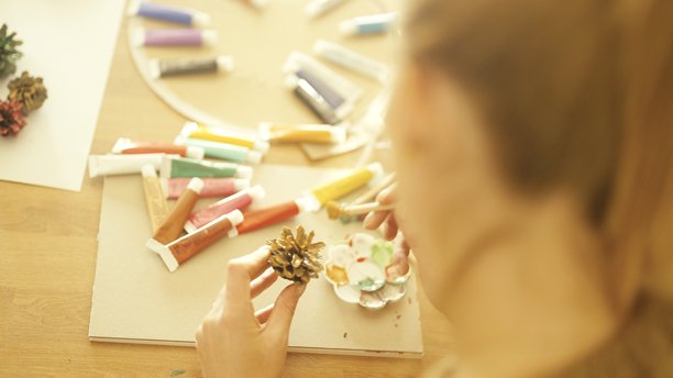 一位女性手绘松果，用于制作圣诞装饰品图片下载