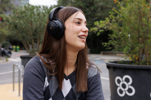 一位年轻女子独自漫步在巴塞罗那的小巷中，面带宁静的自然笑容看向镜头，这是一张适用于商业用途的生活方式样张照片。图片下载