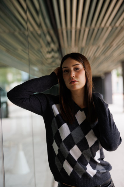 一位年轻女子独自漫步在巴塞罗那街头，面向镜头，捕捉都市生活和现代都市活力，适合用作素材照片。图片下载