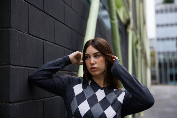 一位年轻女子独自漫步在巴塞罗那街头，看向镜头，姿态放松自信，这是一张用于商业用途的生活方式图片。图片下载