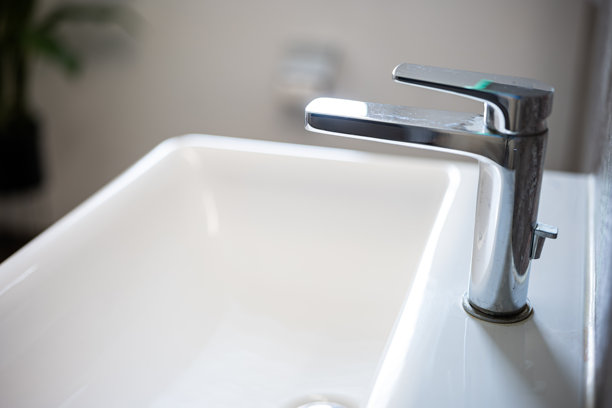 现代方形浴室洗脸盆或水槽，配有镀铬水龙头。广角、侧视、浅景深、自然窗光、无人图片下载