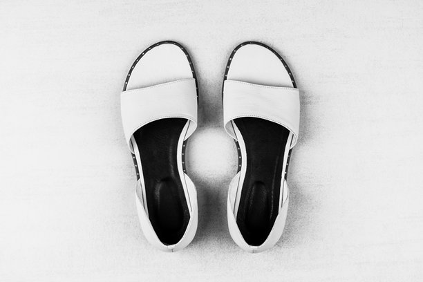 俯视黑白照片：白色背景上的女性夏季凉鞋图片下载