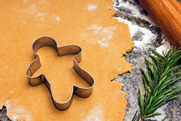 一个金属姜饼人饼干模具放在擀好的姜饼面团上图片下载