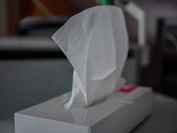 特写：医院病房内的白色纸巾盒中抽出的纸巾，展示了清洁、关怀和无菌用品，用于患者的卫生和康复，医疗保健背景，专业照片图片下载