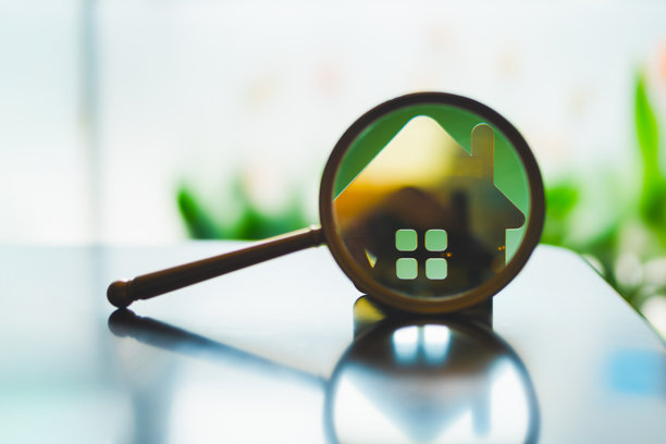 放大镜聚焦房屋图标，象征着物业搜索、房地产分析、房屋搜寻、投资机会、抵押贷款比较和房屋评估的概念。图片下载