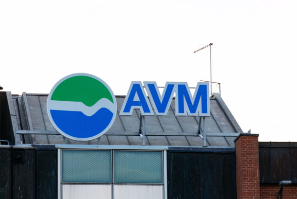 AVM品牌标志醒目地展示在现代建筑的屋顶上，在晴朗的天空背景下，展现着企业标识和建筑细节图片下载