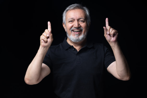 身穿黑色T恤的老年男子，黑色背景中的照片素材图片下载