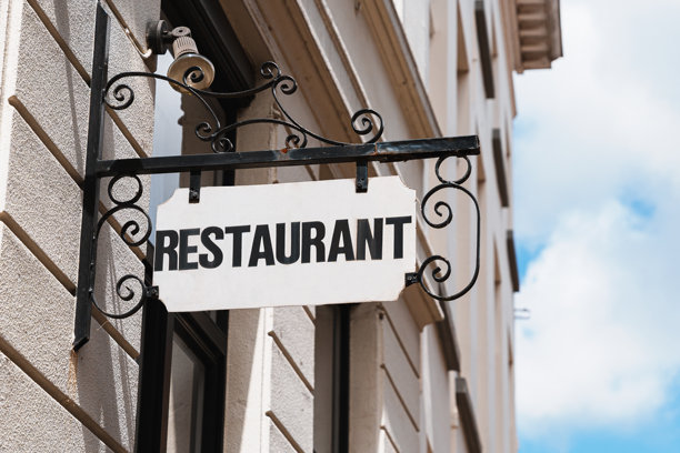 挂在城市墙壁上的复古金属餐厅招牌图片下载