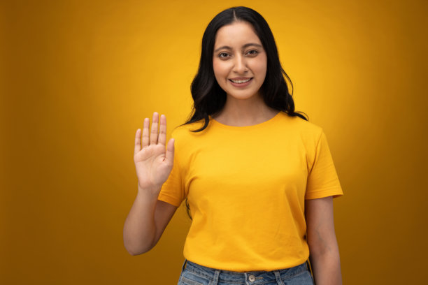 穿着黄色T恤的年轻女子，背景为黄色，摄影素材图片下载