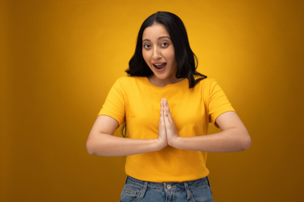 身穿黄色T恤的年轻女子，背景为黄色，摄影素材图片下载