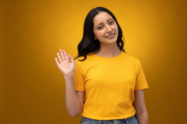 身穿黄色T恤的年轻女子，背景为黄色，孤立的照片素材图片下载