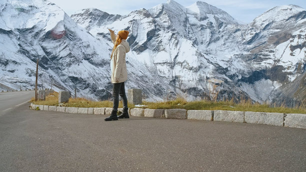 一位女性在冬季的背景下，欣赏着山地景观，并驻足欣赏美景图片下载