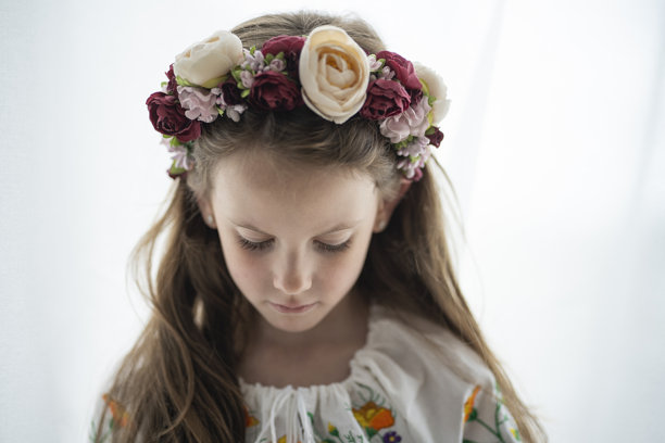 横向照片，一名身着花环和白色刺绣衬衫的乌克兰女孩，低着头，背景为白色，留有复制空间，概念为情感和乌克兰传统图片下载