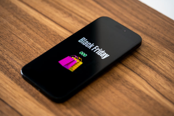 黑色星期五照片。极简黑色星期五符号，手持手机和折扣优惠。适用于黑色星期五销售、广告和社交媒体的横向设计。图片下载