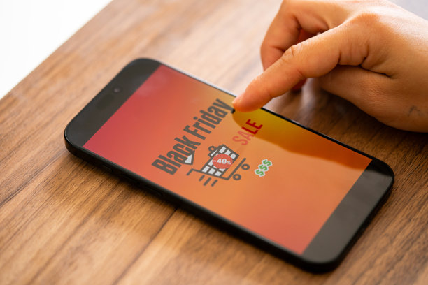 黑色星期五照片。极简风格的黑色星期五标志，手持手机和折扣优惠。适用于黑色星期五销售、广告和社交媒体的横幅设计。图片下载