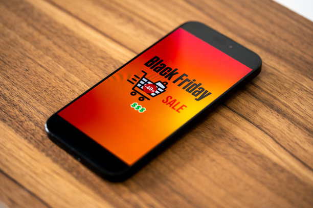 黑色星期五照片。简约的黑色星期五符号，手持手机和折扣优惠。适用于黑色星期五销售、广告和社交媒体的横向设计。图片下载