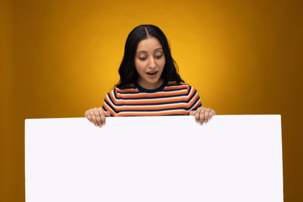 一名年轻女子手持横幅，背景为黄色，横幅和女子均被孤立的存货照片图片下载