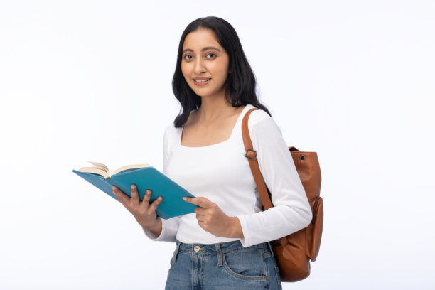 年轻的女学生背着书包，手里拿着书，在白色背景下被隔离的素材照片图片下载