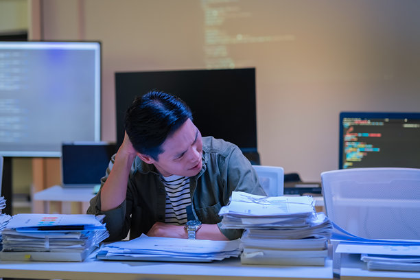 亚洲男性程序员深夜在办公室专注于深度学习人工智能模型，训练神经网络，独自加班进行机器学习。图片下载