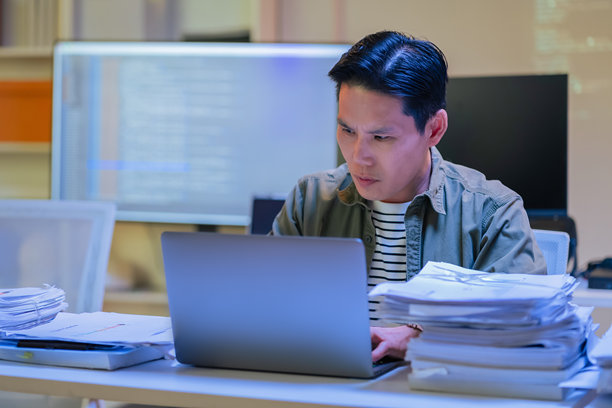 亚洲男性程序员深夜在办公室专注地编写深度学习人工智能模型代码，独自加班加点训练神经网络，进行机器学习。图片下载