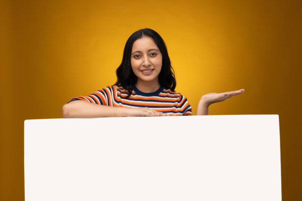 年轻女子举着广告牌的特写照片 - 牌子孤立在黄色背景上图片下载