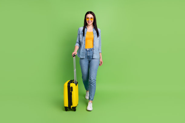快乐的漂亮女人戴着太阳镜，带着行李，准备度假，孤立在绿色背景上，全尺寸照片图片下载