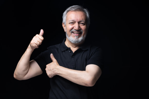 身穿黑色T恤的老年男子，黑色背景下的黑白照片图片下载