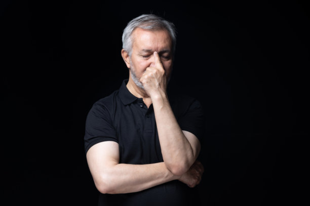 身穿黑色T恤的老年男性，在黑色背景下拍摄的照片素材图片下载